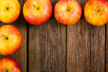 Wall Mural - apple fruits frame background, old weathered wood table