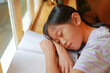 © zilvergolf - Asian young girl child sleeping on a book near the windows. Education and resting concept.
