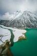 Vertical aerial shot of the Ranwu lake in Tibet, covered with snow and surrounded by hills