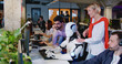 © ihorvsn - Happy multietnic people standing and looking at humanoid working in office. Robot typing on keyboard at call center. Futuristic support service. Men and women cheering up for droid work.
