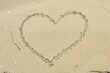 Drawing of a heart on a yellow sand