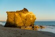 Rocks in El Matador Beach Malibu with waves washing the coastline during sunset