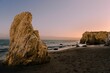 Rocks in El Matador Beach Malibu with waves washing the coastline during sunset
