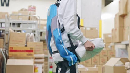 Poster - 食品倉庫でパワーアシストスーツを着て荷物を持ち上げる女性