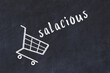 Chalk drawing of shopping cart and word salacious on black chalboard. Concept of globalization and mass consuming