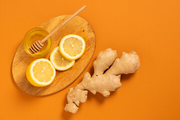 Wall Mural - Fresh ginger root lemon honey orange background. Alternative medicine vegetarianism