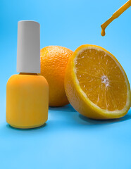 Wall Mural - Bright bottle of nail polish on a blue background with orange fruits