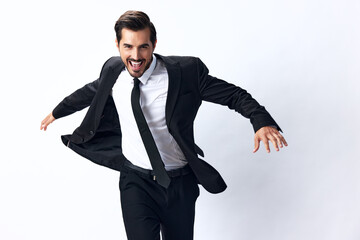 Wall Mural - A business man jumps in a business suit and smiles with his teeth on a white isolated background running. The concept of a happy businessman