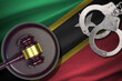 Saint Kitts and Nevis flag with judge mallet and handcuffs in dark room. Concept of criminal and punishment, background for judgement topics