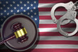 United States of America flag with judge mallet and handcuffs in dark room. Concept of criminal and punishment, background for judgement topics