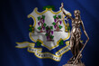 Connecticut US state flag with statue of lady justice and judicial scales in dark room. Concept of judgement and punishment