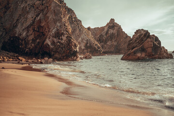 an extremely beautiful and secluded beach on the ocean coast in Portugal. rocks on the ocean shore.