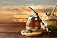 Calabash With Mate Tea And Bombilla On Wooden Table Outdoors At Sunset. Space For Text