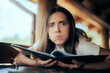© nicoletaionescu - Woman Checking the Prices in a Restaurant Surprised by InflationFunny girl trying to decide what to eat
