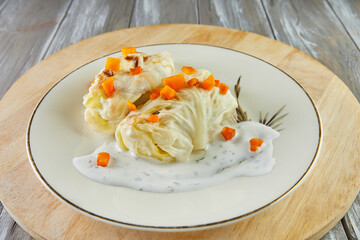 Wall Mural - Cabbage rolls with carrots and sauce served on plate. French recipe