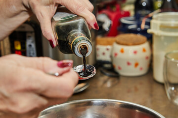 Wall Mural - Chef pours soybean oil from bottle into sliced strawberries for dessert