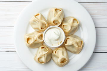 Wall Mural - Russian meat dumplings with sour cream on white plate