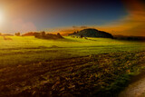 Krajobraz pól rolnych z pagórkami w porze zachodzącego słońca