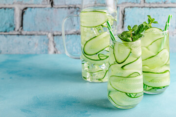 Wall Mural - Fresh infused cucumber water on a light blue background