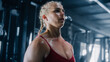 Close up on the Face of a Beautiful Female Athlete in a Dark Gym . Strong Female Bodybuilder Focused on her Exercises and Workout while Training for Future Performance