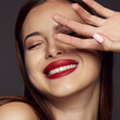 © Lustre Art Group  - Close-up portrait of young beautiful girl with red lips and white teeth smiling, posing isolated over dark grey background. Dental care. Concept of beauty, fashion and cosmetology