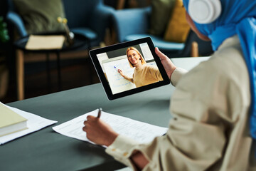 Poster - Focus on tablet screen with blond confident teacher pointing at whiteboard during explanation of English grammar to online audience