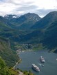 Vertical aerial shot of ships in the sea near mountains in Norway