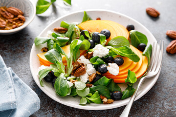 Sticker - Persimmon fruit salad with blueberry, pecan nuts and ricotta chesse. Healthy food. Top view