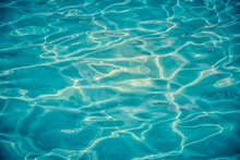 Azure Clear Water In A Swimming Pool With Sun Reflecting