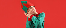 Cute Sleepy Boy In Elf's Costume On Red Background