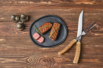 Wall Mural - Overhead view of grilled beef steaks on wooden serving board