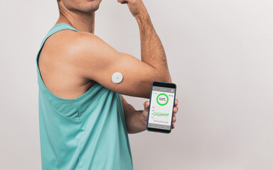 Unrecognizable young man shows his mobile with a continuous glucose monitor blood sugar test application, glucose measurement.