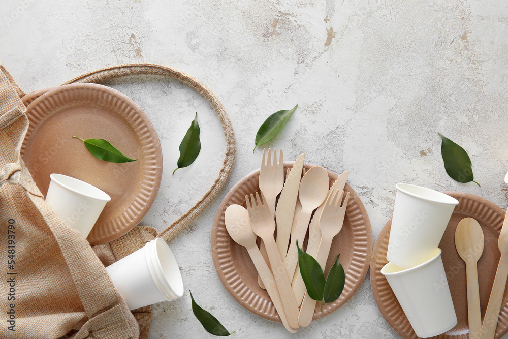Tote bag with Eco tableware and plant leaves on light background