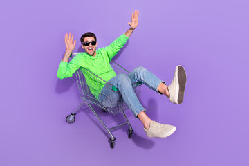 Poster - Full length photo of impressed funny guy dressed neon sweatshirt dark eyewear shopping tray rider isolated violet color background