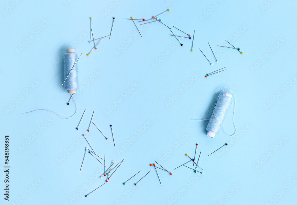 Frame made of thread spools and ball pins on color background