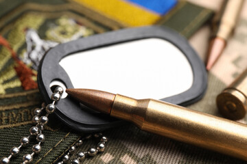 Wall Mural - Bullets, military ID tag and Ukrainian patch on pixel camouflage, closeup