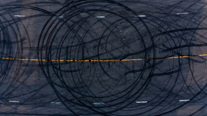 Wall Mural - Top view tire tracks texture and background. Asphalt texture with line and tire marks. Automobile automotive tire skid mark on race track. Abstract texture car drift tire skid mark.