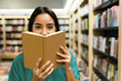 © AntonioDiaz - Smiling woman reading a happy book while shopping at the bookstore