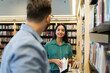 © AntonioDiaz - Happy woman and man flirting while at the book shop