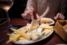 Anonymous Woman Eating Cheese Board With Wine