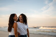 © Brett Edwards/Adobe Stock - Hispanic lesbian couple stand by the ocean holding hands