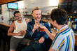 © Brett Edwards/Adobe Stock - LGBTQ Friends sit at a bar with beer and champagne
