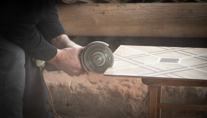 Poster - Worker cutting a ceramic tile with a grinder.