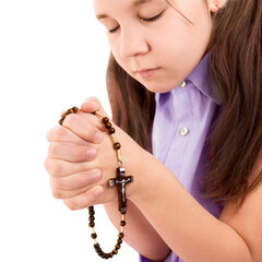 girl child praying holding wooden rosary in hands on close up