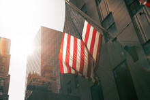An American Flag Glows In The Sun In An Urban Landscape.