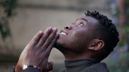 Spiritual young black African man praying to God