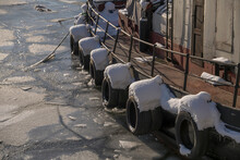 Snowy Tire Fenders On The Side Of An Old Tug Boat, Ice Floaters A Sunny Winter Day In Stockholm