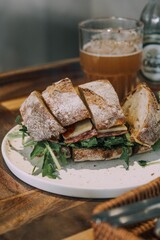 Sticker - Vertical closeup shot of a delicious sandwich with greens served with beer