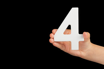 Aufkleber - Number four in hand isolated on black background. Number four in a child's hand, holding on a black background. To be inserted into a project or design.