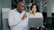 © Yuliia - Diverse colleagues two business partners african arabian co-workers discuss internet project on laptop at office meeting planning working main tasks partnership cooperation managing corporate teamwork